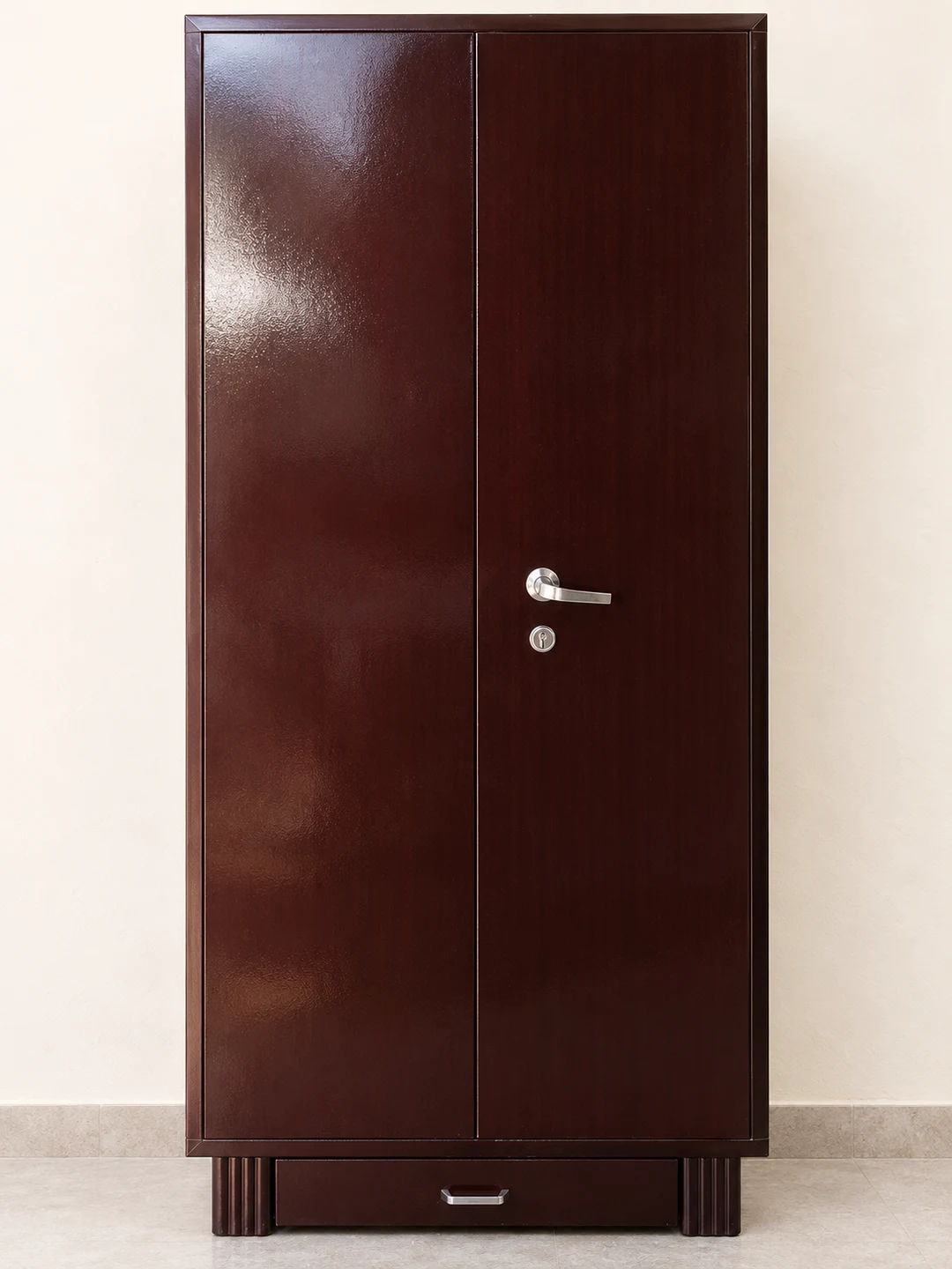 Brown two-door iron almirah with a lower drawer and ribbed supporting feet